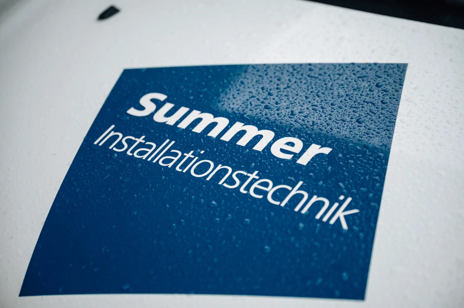 Das Summer-Logo auf dem Firmenbus, mit Regentropfen
